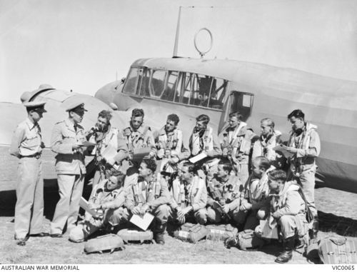 RAAF trainees being briefed for an airborne exercise in front of an Avro Anson